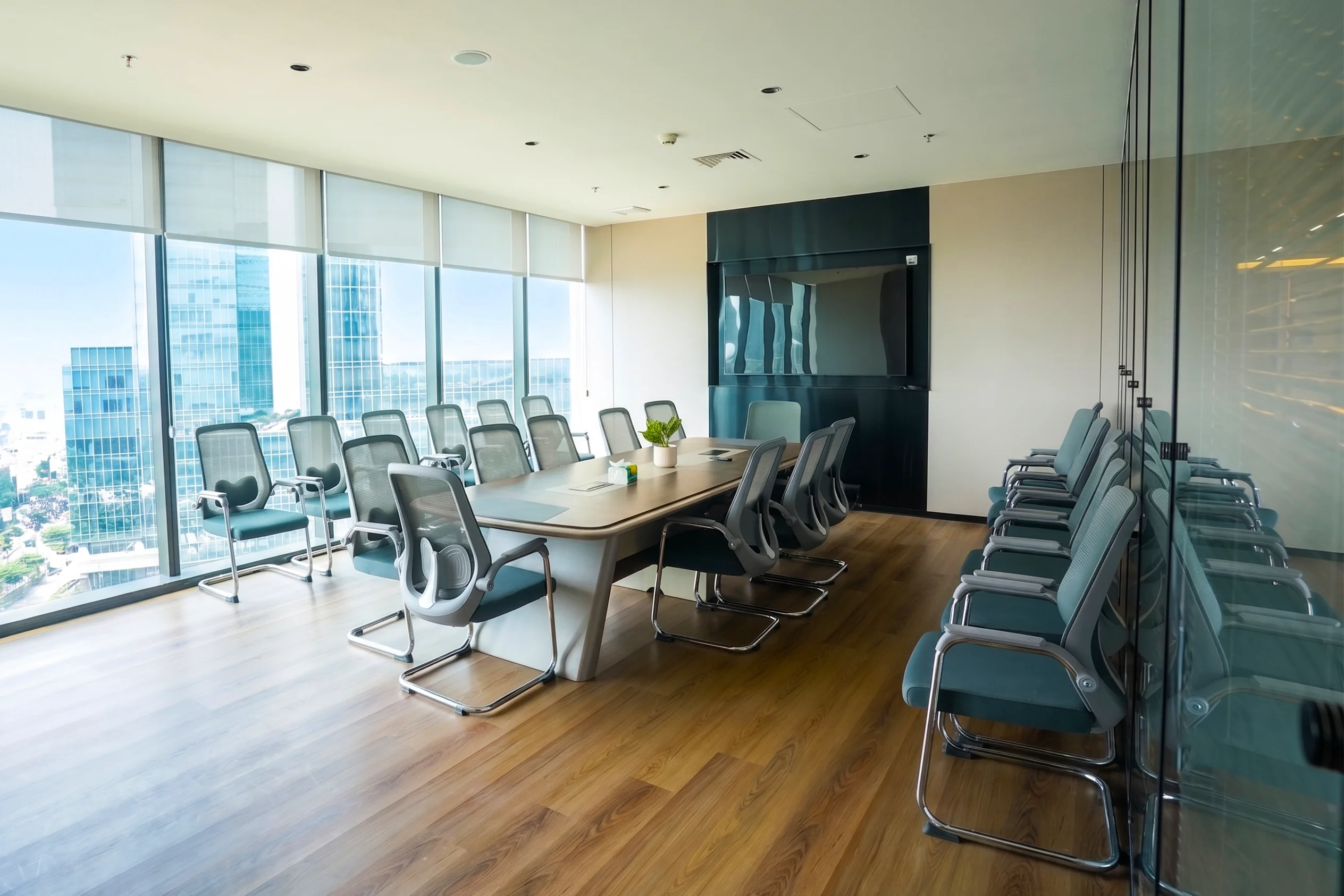 Ruang kantor Go-Day dengan meja rapat panjang, kursi kantor, dan pemandangan kota